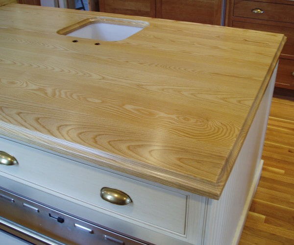 1 1/2" thick ash premium wide plank island top. Natural color with Marine Oil Finish and an ogee-A edge.